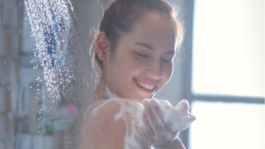 woman washing in the shower with foaming shower gel