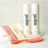 myni hair care essentials set with eco-friendly concentrated shampoo and conditioner as well as a red hairbrush