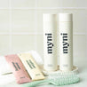 myni hair care essentials set with eco-friendly concentrated shampoo and conditioner as well as a green hairbrush