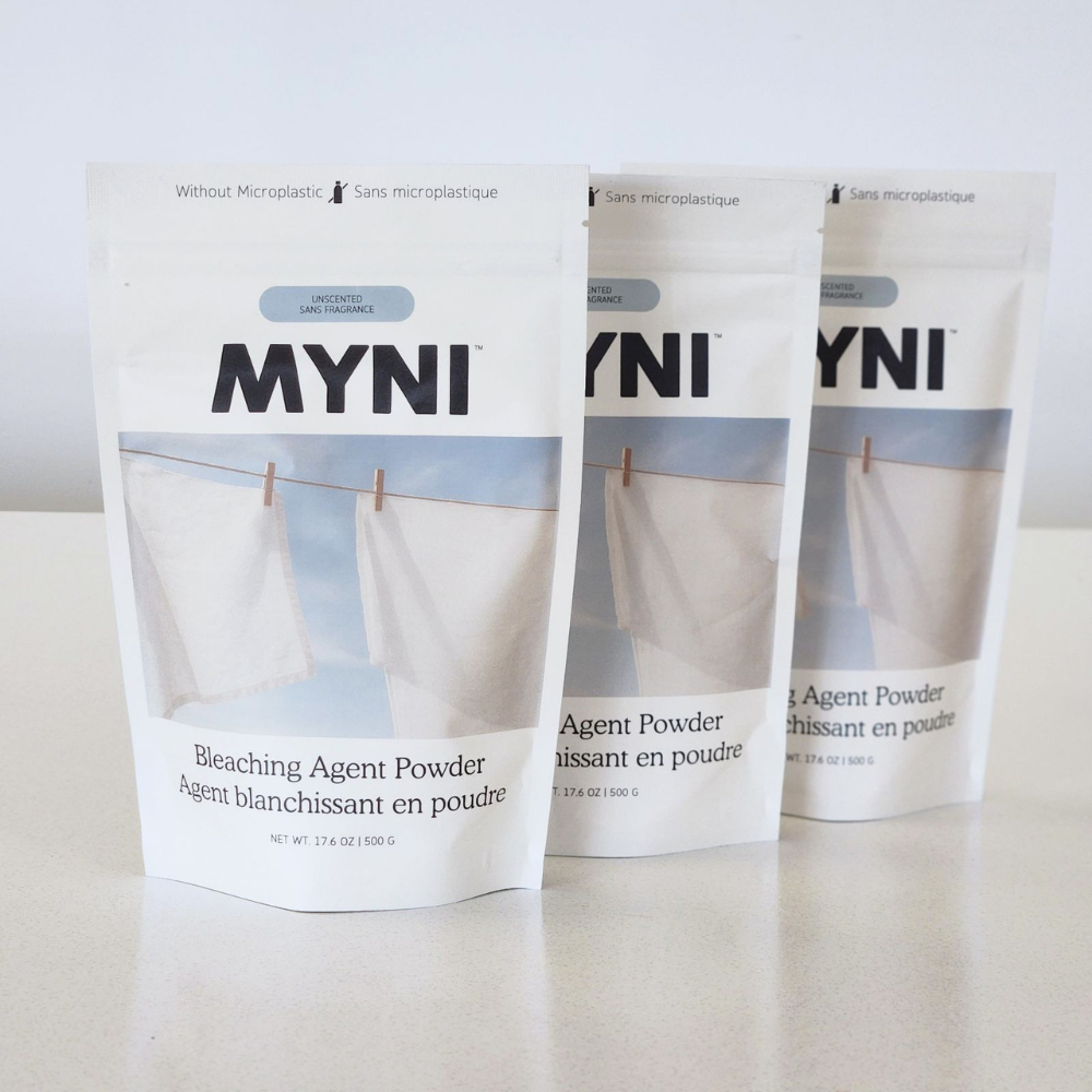 Three packages of MYNI bleaching agent powder on a white background