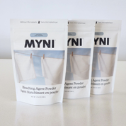 Three packages of MYNI bleaching agent powder on a white background