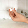 hand holding laundry detergent tablet